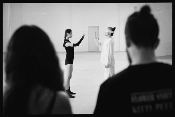 J and Hitomi watch the dancers rehearse the choreography of "On Trust"