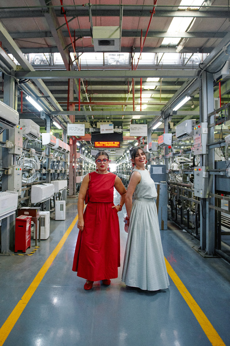 Mina Al Sheikhly and Soleen Mohammed posing next to a quality control halway of Midea's factory